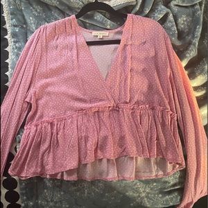 This is a pink crop top with white flowers scattered throughout the top.